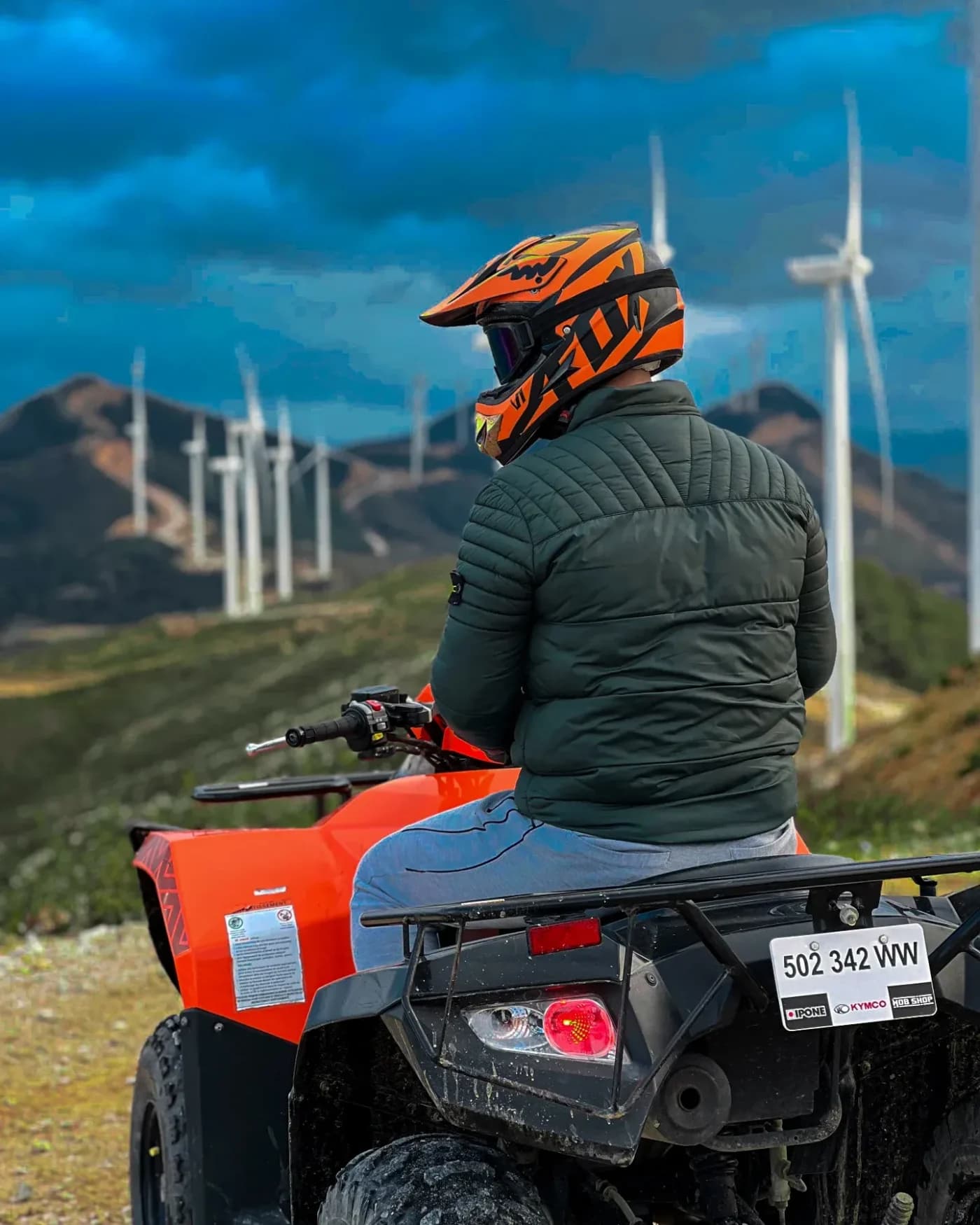 Pilote casqué sur un quad face aux collines